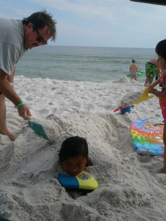 Daddy and Karis burying Kasen in the sand